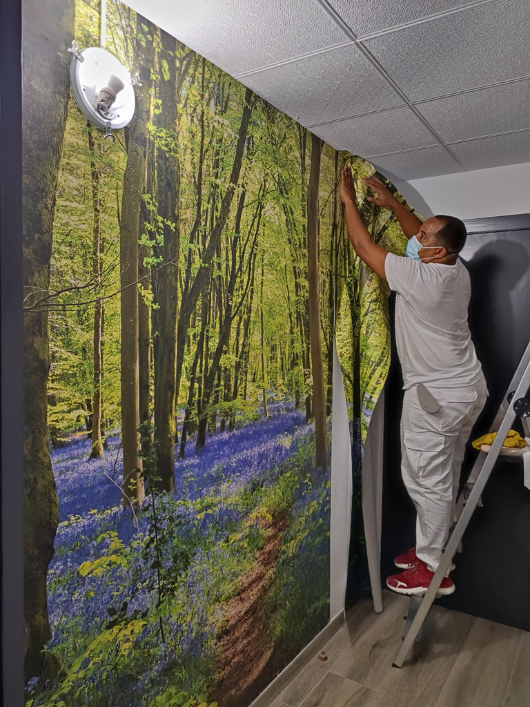 Empapelador Barcelona , Colocando un mural de bosque en recibidor