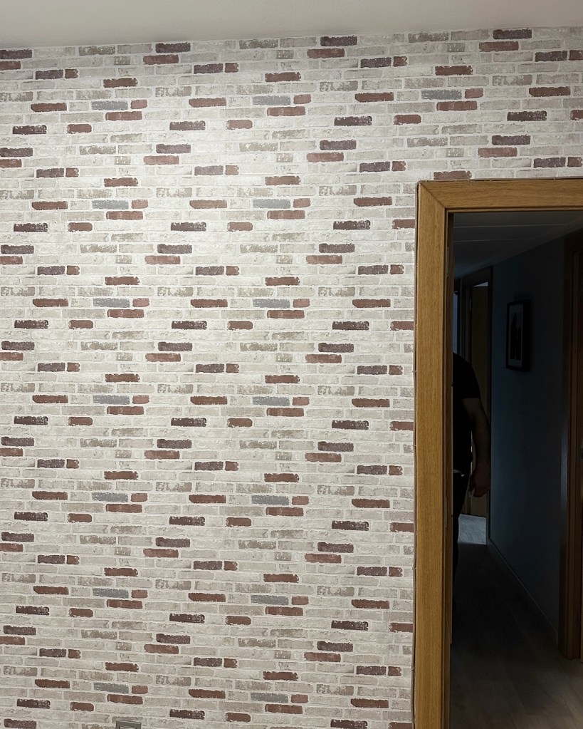 pared empapelada con papel pintado imitación ladrillo, trabajo realizado por empapelador barcelona
