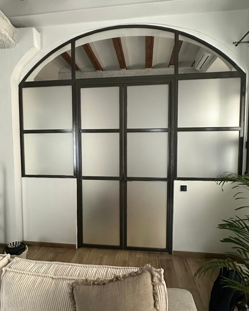 Resultado final de la instalación de vinilo glaseado en un cerramiento acristalado con puerta y cuarterones.