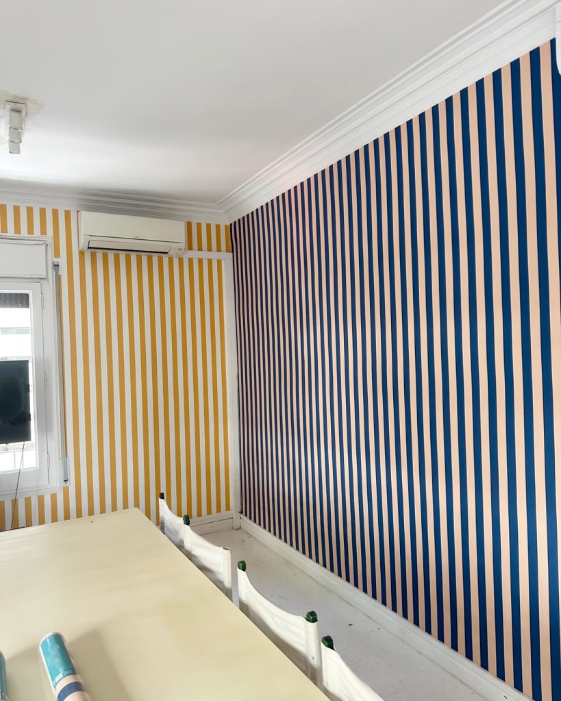 Instalación de dos papeles pintados de rayas en una sala de reuniones