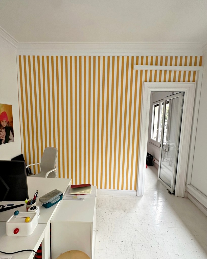 Instalación de papel pintado de rayas blancas y ocres para decorar las oficinas de TinyCottons